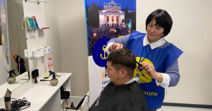 перукар робить зачіску чоловікові з Маріуполя
